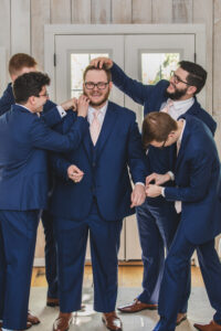 Groomsmen fixing groom