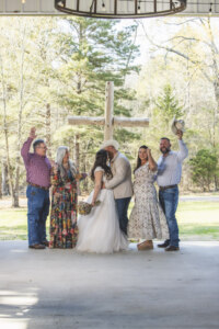 Bride and groom kissing with crowd cheering.