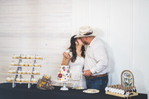 Bride and Groom kissing after cutting the cake