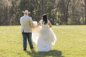 Bride and Groom walking in a field