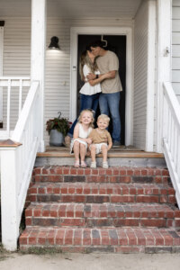 Kids on the front porch with parents behind them