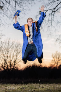 Boy in a cap and gown jumping in the air